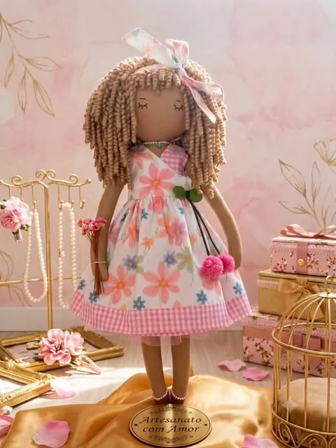 Boneca de pele escura com cachos longos, laço e vestido floral rosa